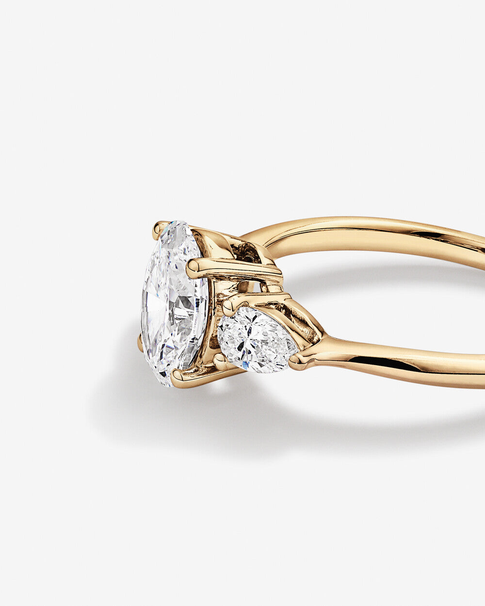 Oval Diamond Ring with Pear Side Stones in Yellow Gold